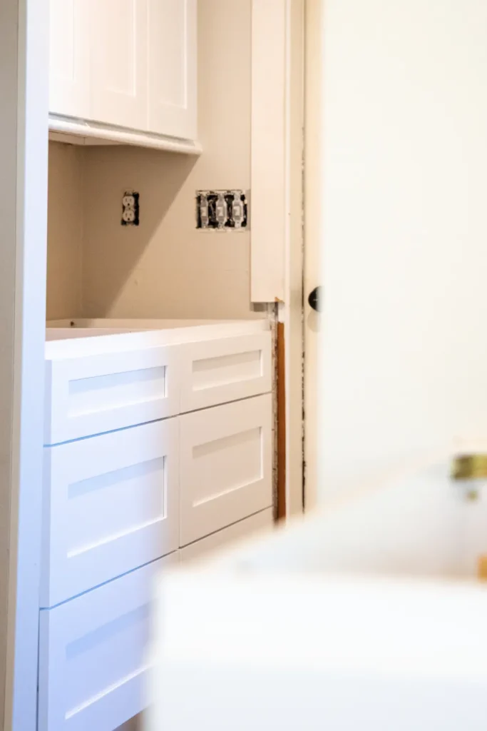 Kitchen with white cabinets and exposed electrical outlets