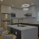 Modern kitchen with a central island, two bar stools, and stainless steel appliances